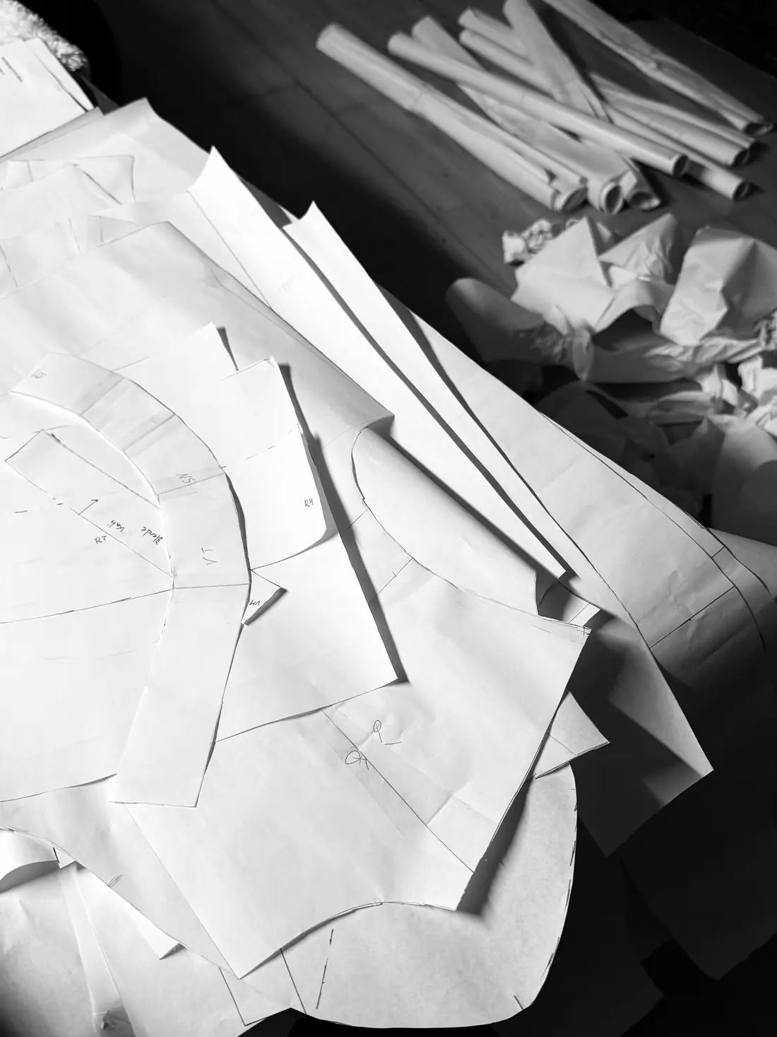Paper pattern pieces piled up on the cutting table.